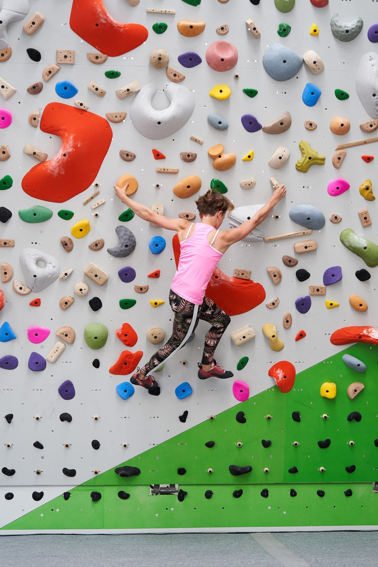 Picture of a girl climbing a colorful bouldering wall