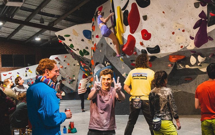 A person holding up the peace symbol at some of the best rock climbing Melbourne has to offer. 