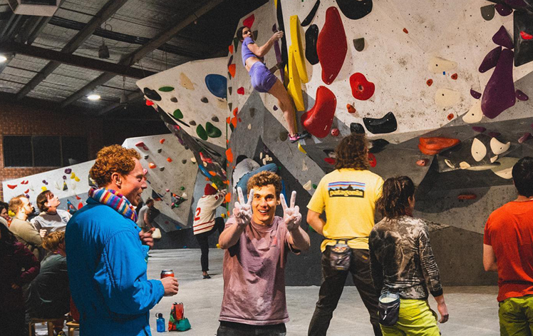 A person holding up the peace symbol at some of the best rock climbing Melbourne has to offer. 