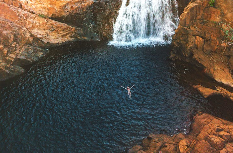A woman floating in a waterhole at  Edith Falls