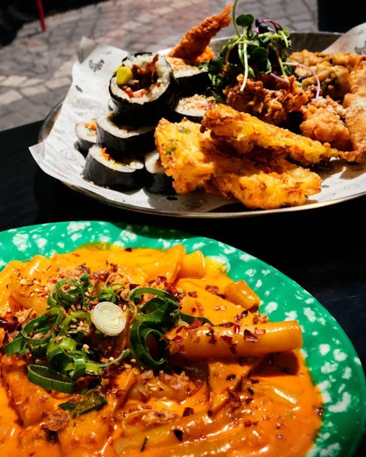 Dishes of tteokbokki (chewy rice cakes with spicy sauce), gimbap and fried treats.