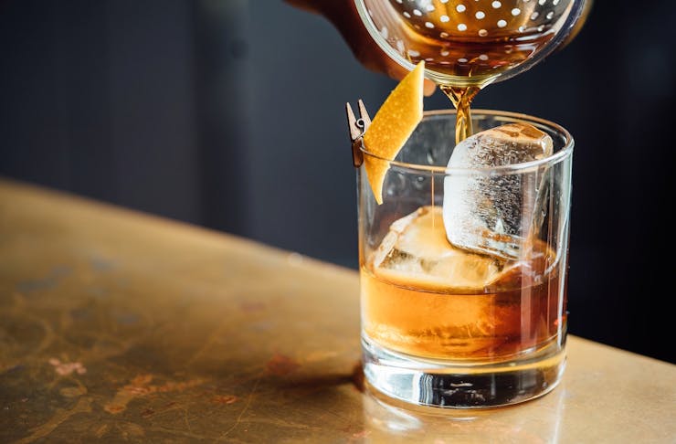 An old fashioned being poured into a short glass