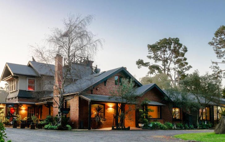 A large lit up house at dusk, a best yarra valley winery accommodation. 