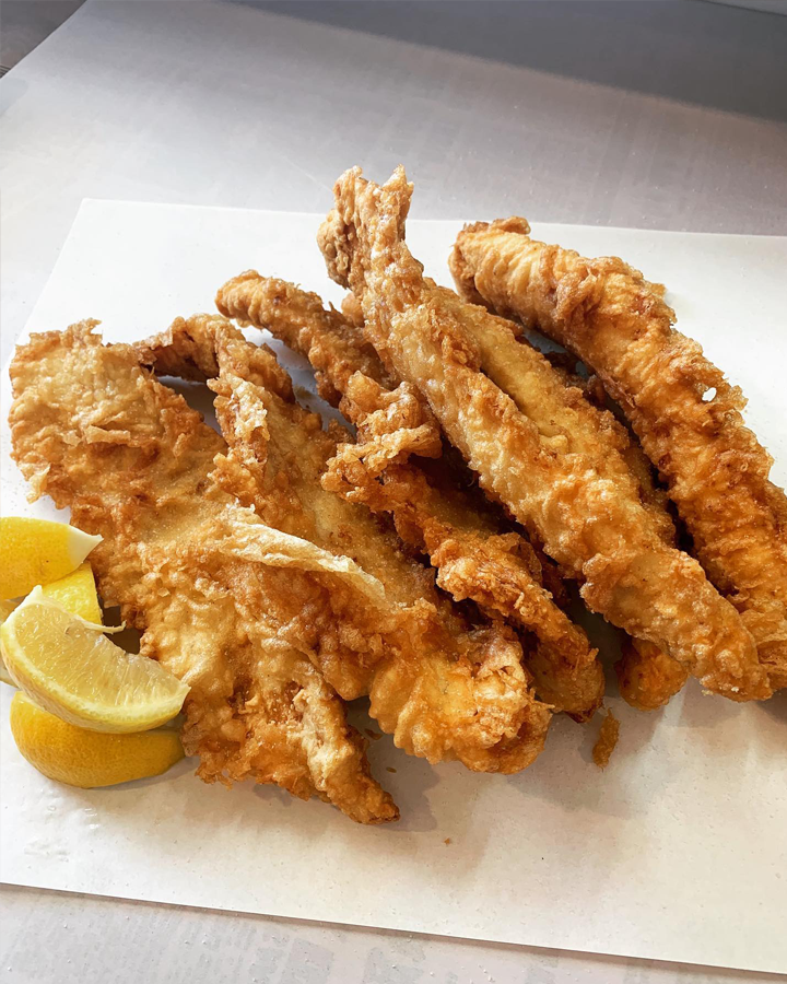 A cluster of fried fish with lemon at a best fish and chips shop Melbourne