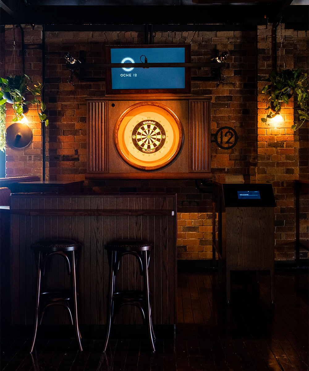 a dart board with a tv above it, at oche, an idea for Fathers Day Brisbane