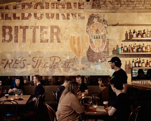 A bar with people sitting at tables drinking. 