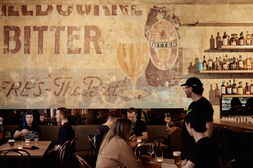A bar with people sitting at tables drinking.