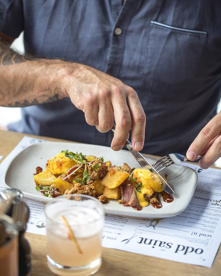 Someone tucks into a hearty breakfast at odd saint, one of the best cafes in Queenstown.