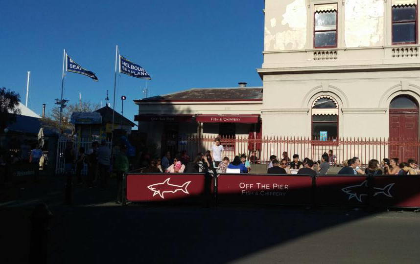 The front of a fish and chip Melbourne shop with people dining.