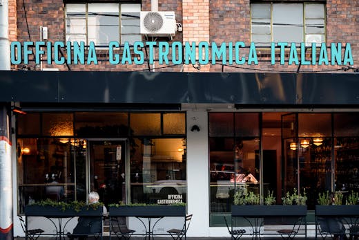 The exterior to a shopfront with people dining.