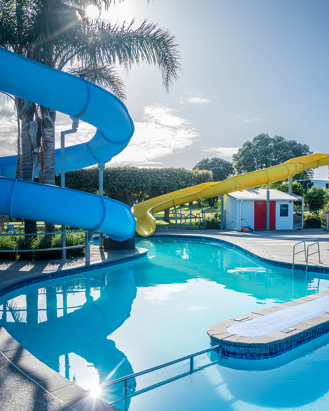 An outdoor pool complete with slides at Ohope Beach Holiday Park, one of the best camping grounds near Tauranga.