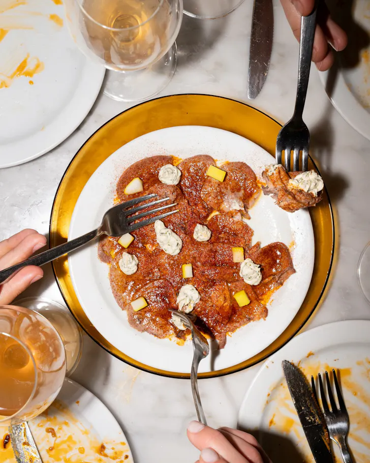 Diners dig in to a plate of charcuterie in Oido, Barcelona. 