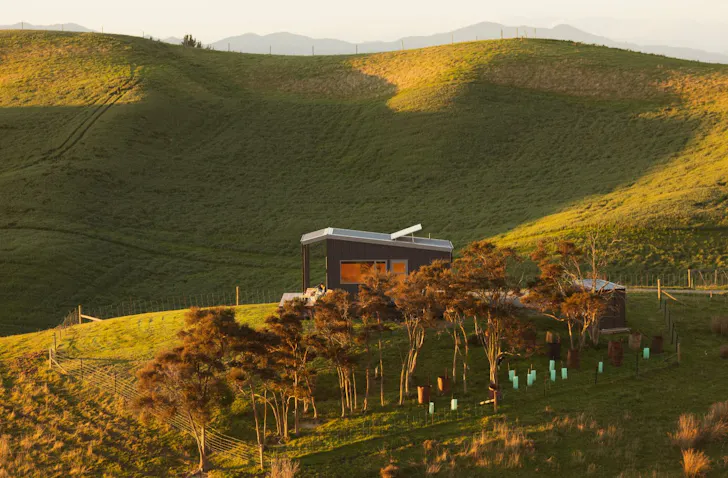 A view of Omaka Valley Hut surrounded by rolling hills best tiny homes New Zealand