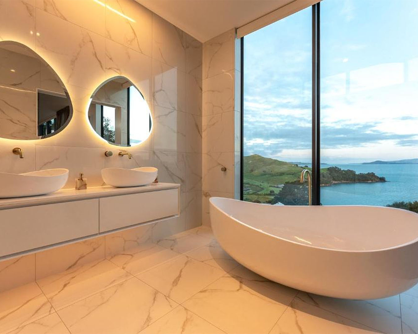 The bathroom overlooking the water at Omaha Luxury Villa, one of the most romantic getaways in Auckland. 