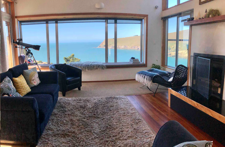 A cosy bach vibe with a jaw-dropping view of the beach at Te Onopoto Lodge, one of the best Airbnbs in Christchurch. 