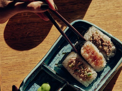 A person eating Onigiri at a table. 