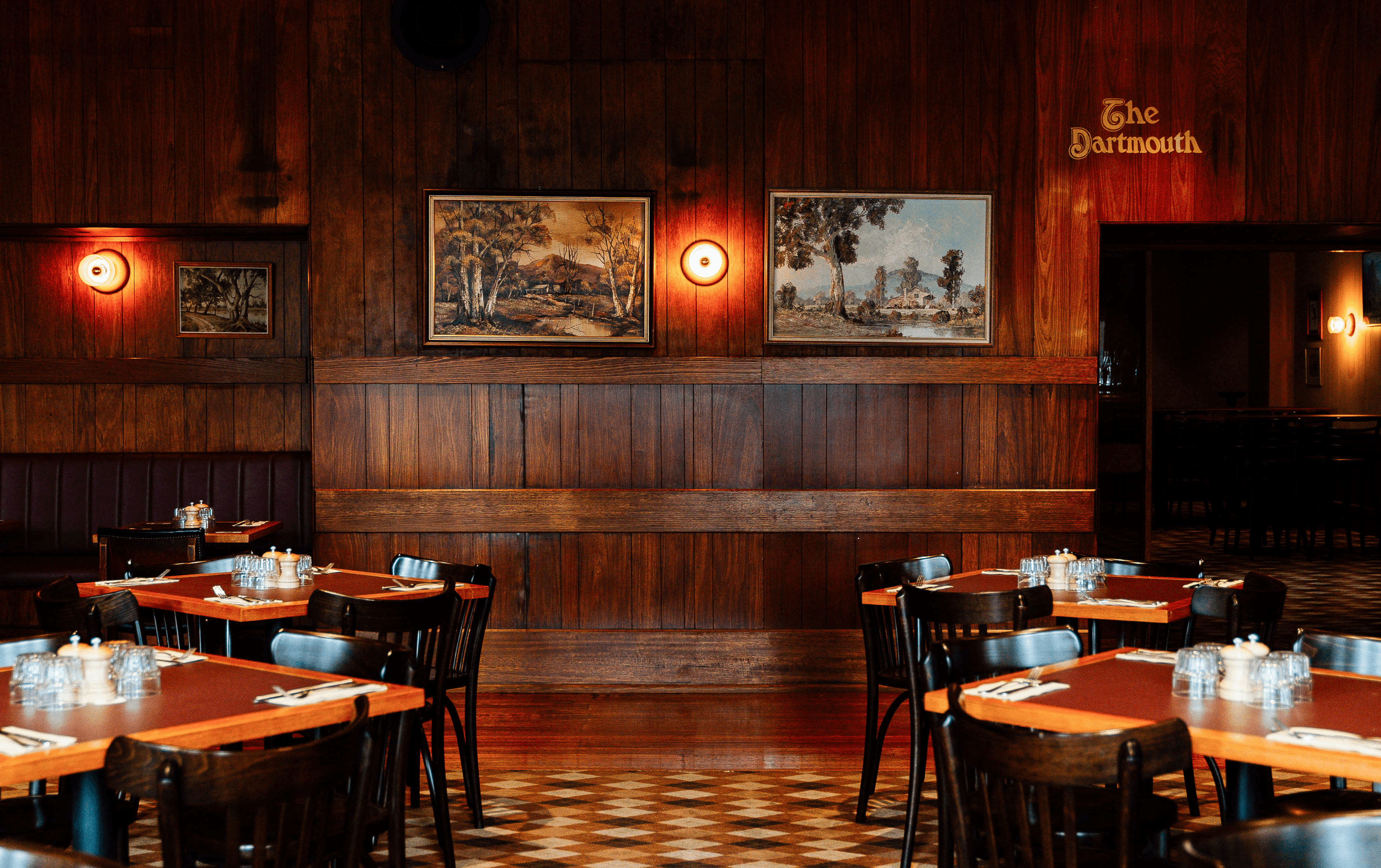 A 70s-style dining room with prints on the wall at one of the best pubs in Melbourne.