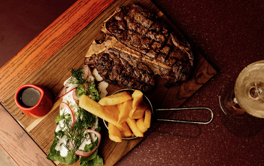 A wooden board with salad, chips and one of the best steaks in Melbourne. 