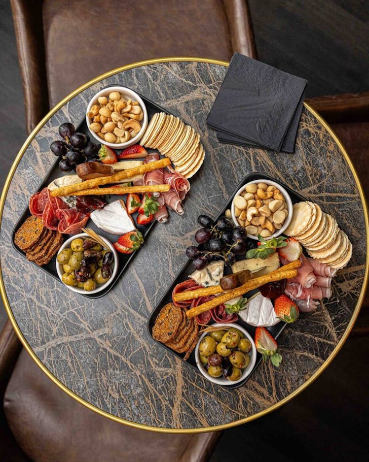 Charcuterie boards on a dark table at Osk Bar, Townsville. 