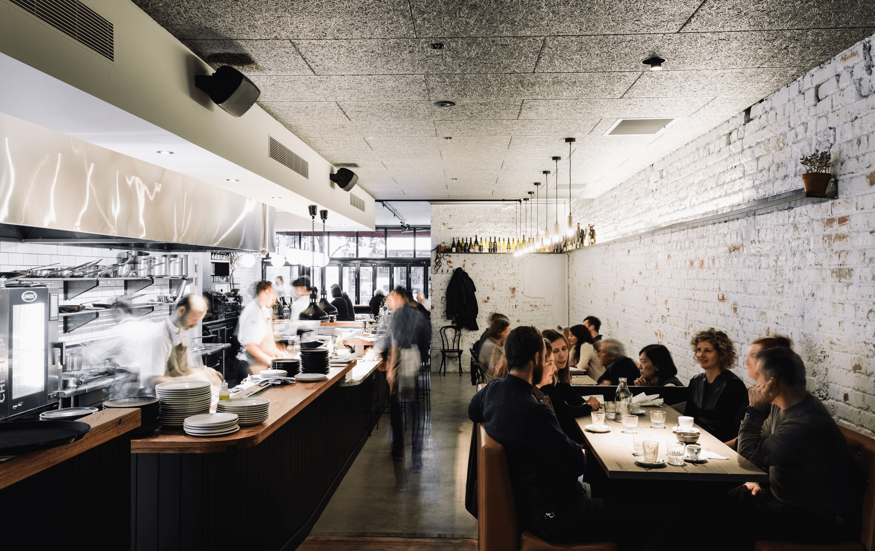 A long, thin restaurant bar where people are dining. Situated in Melbourne.