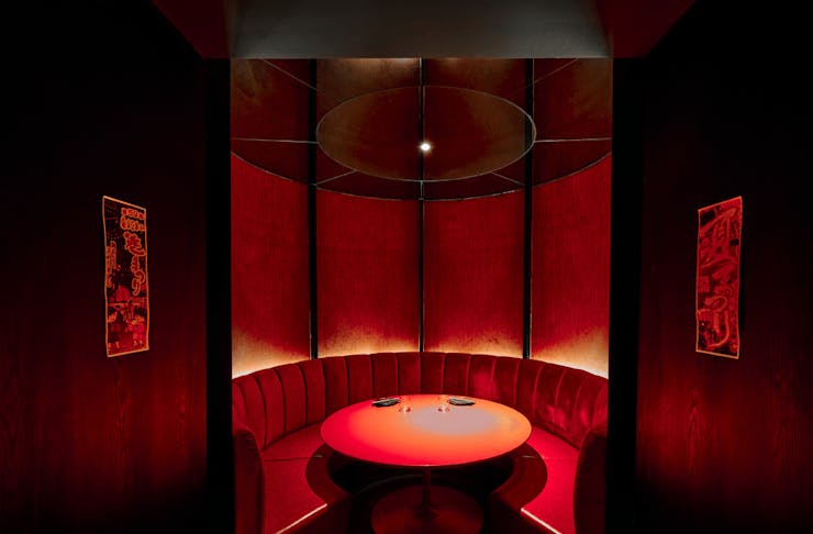 A private dining room with red booth couches. 