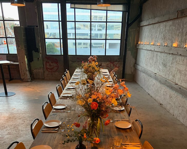 An industrial, minimalist table setting with flowers. 