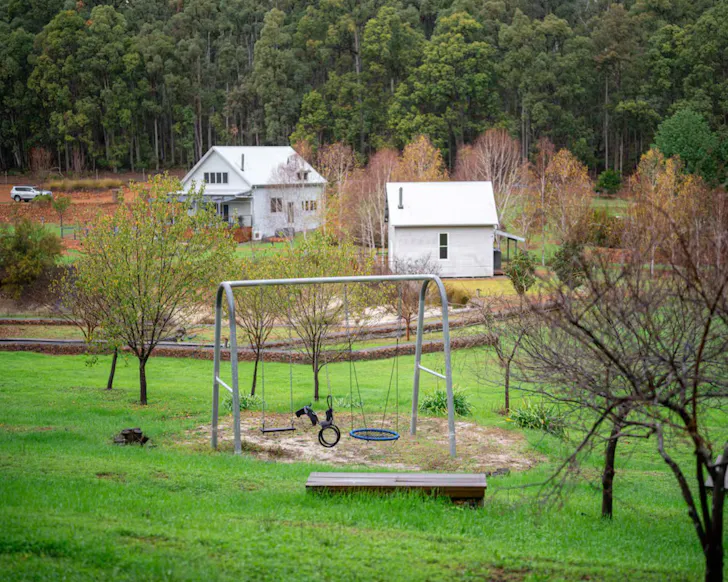 A view of the swing in front of the house at Overlock Park one of the best kid-friendly Airbnbs in Australia