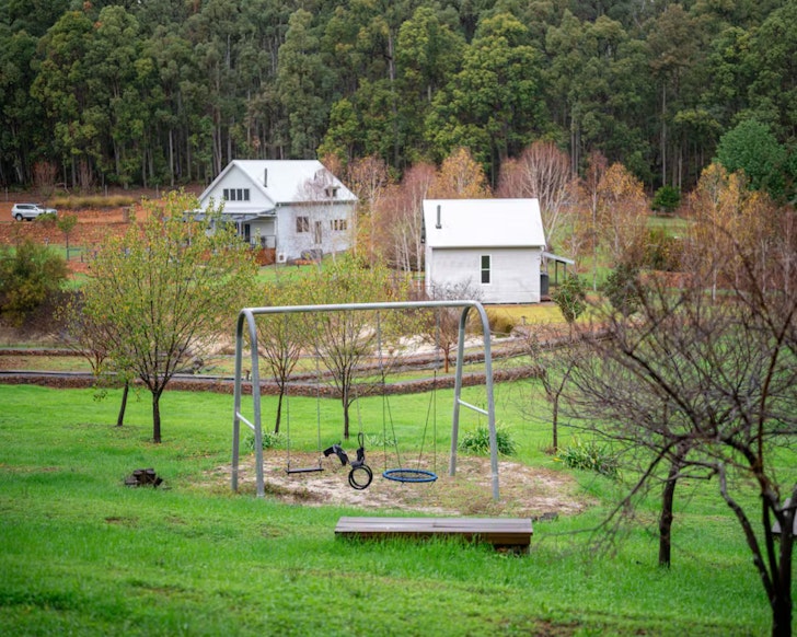 A view of the swing in front of the house at Overlock Park one of the best kid-friendly Airbnbs in Australia