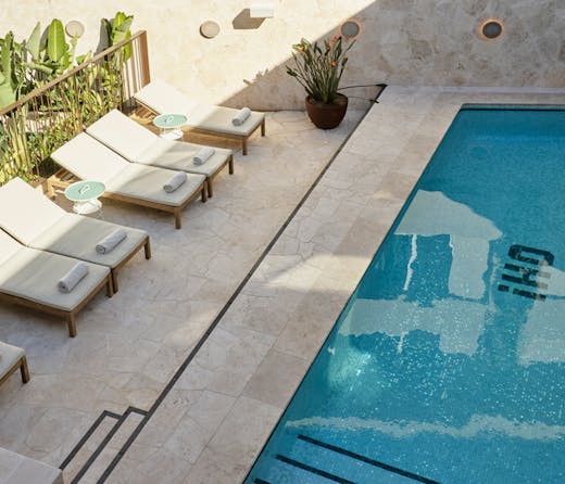 A hotel pool with sun loungers