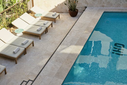A hotel pool with sun loungers