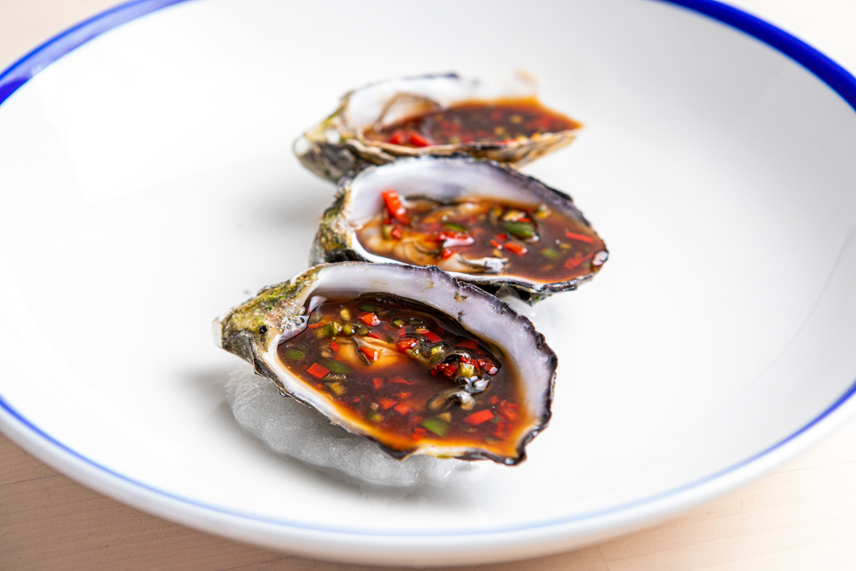 Three oysters on a white plate