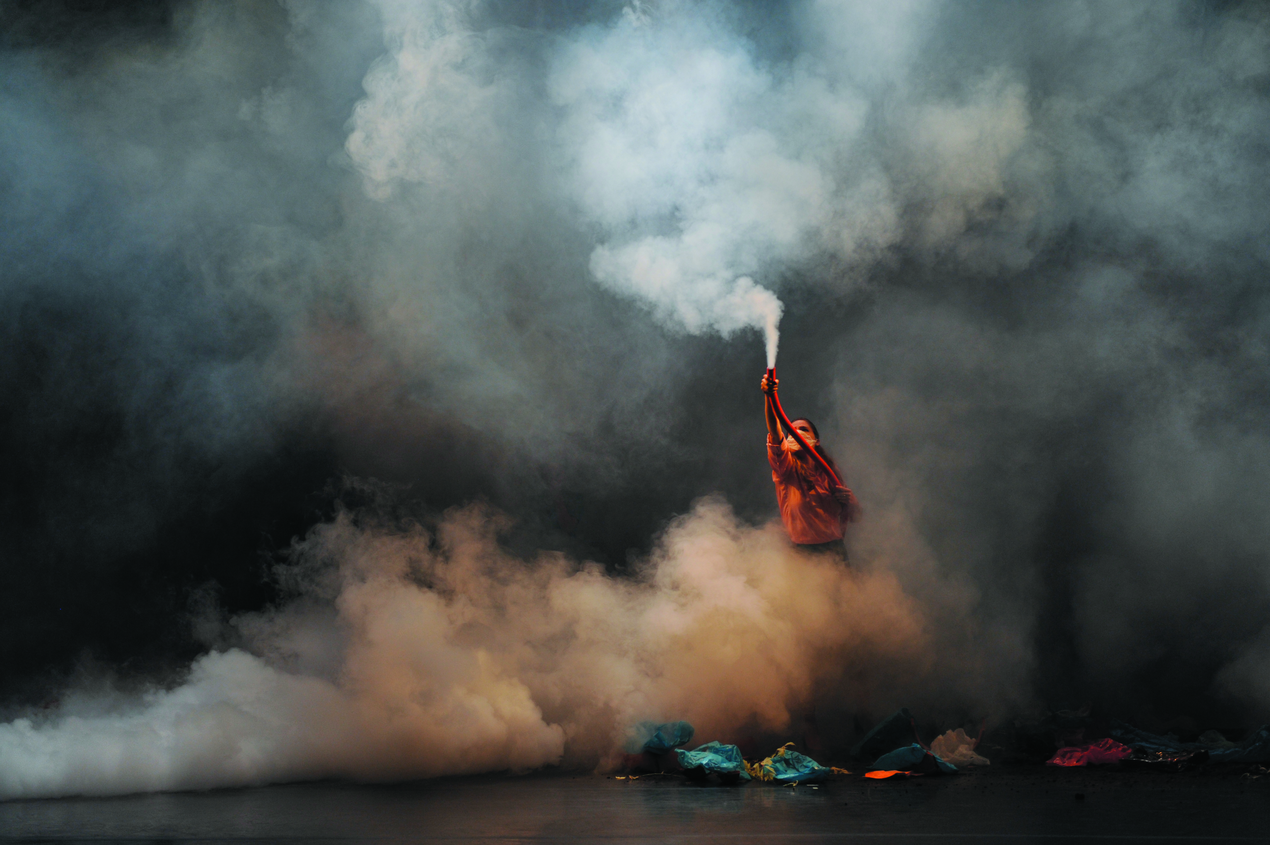 Person performing on stage with smoke.