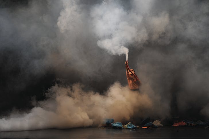 Person performing on stage with smoke.
