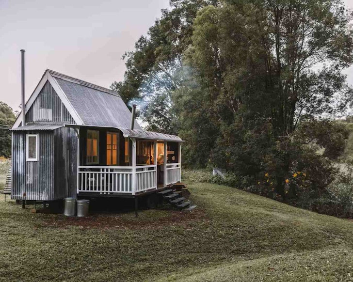 A view of Palmer & Gunn tiny home with smoke coming from the chimney in South East Queensland