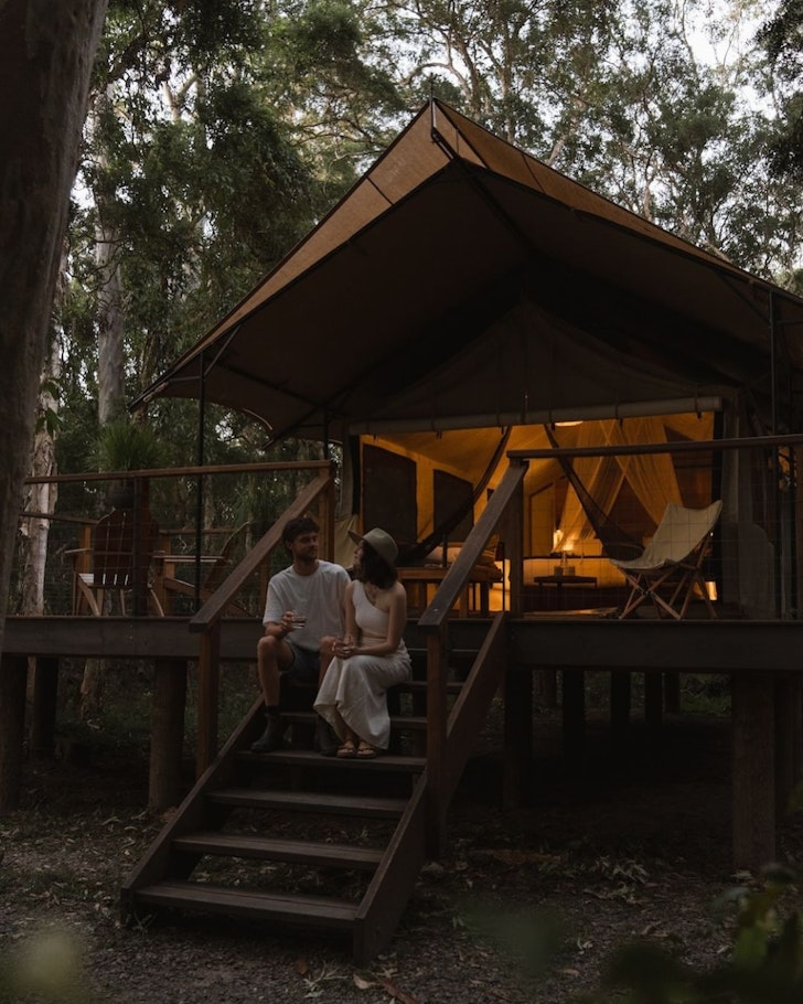 A couple sits outside one of the romantic tents at Paperbark Camp one of the best romantic getaways in Australia