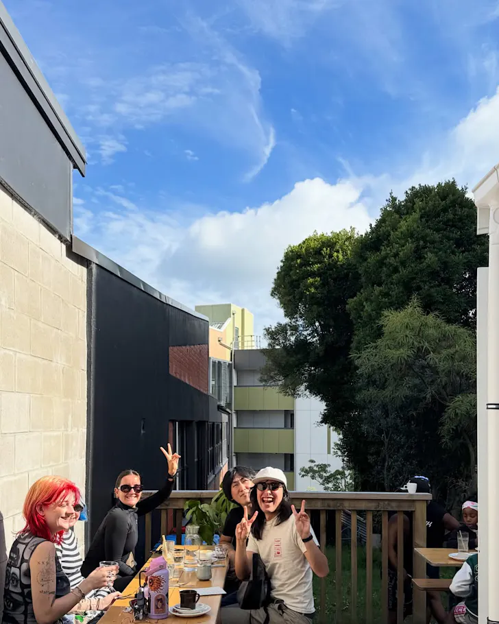 A bunch of friends sit on an outdoor table at Parable House.
