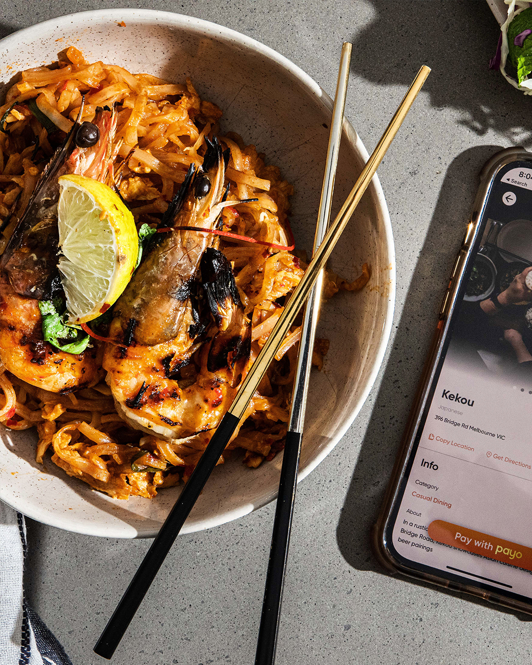 A featuring prawns next to a phone with the Payo app open