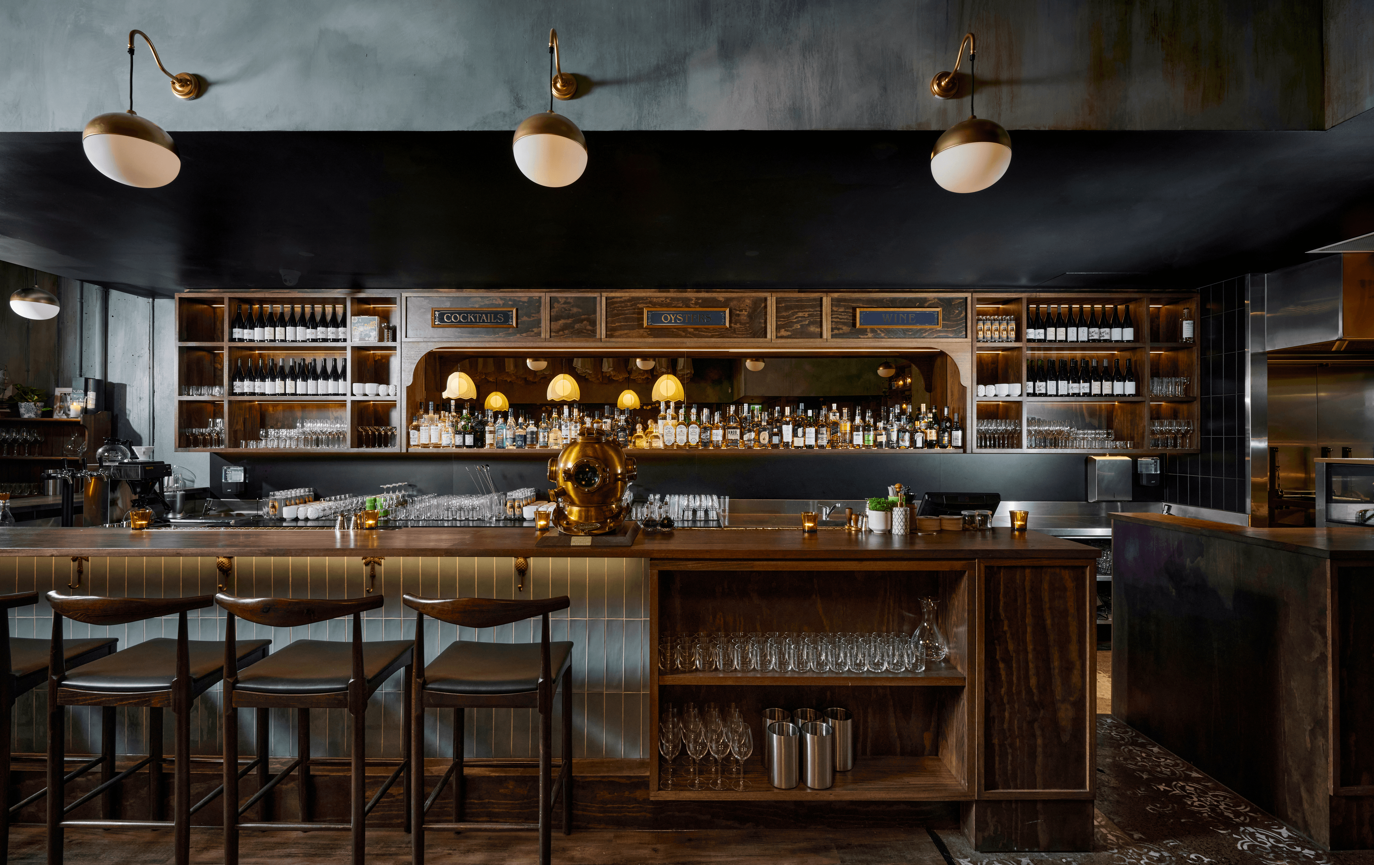 Chairs and bottles lined up at one of the best bars in Melbourne with pendant lights hanging.
