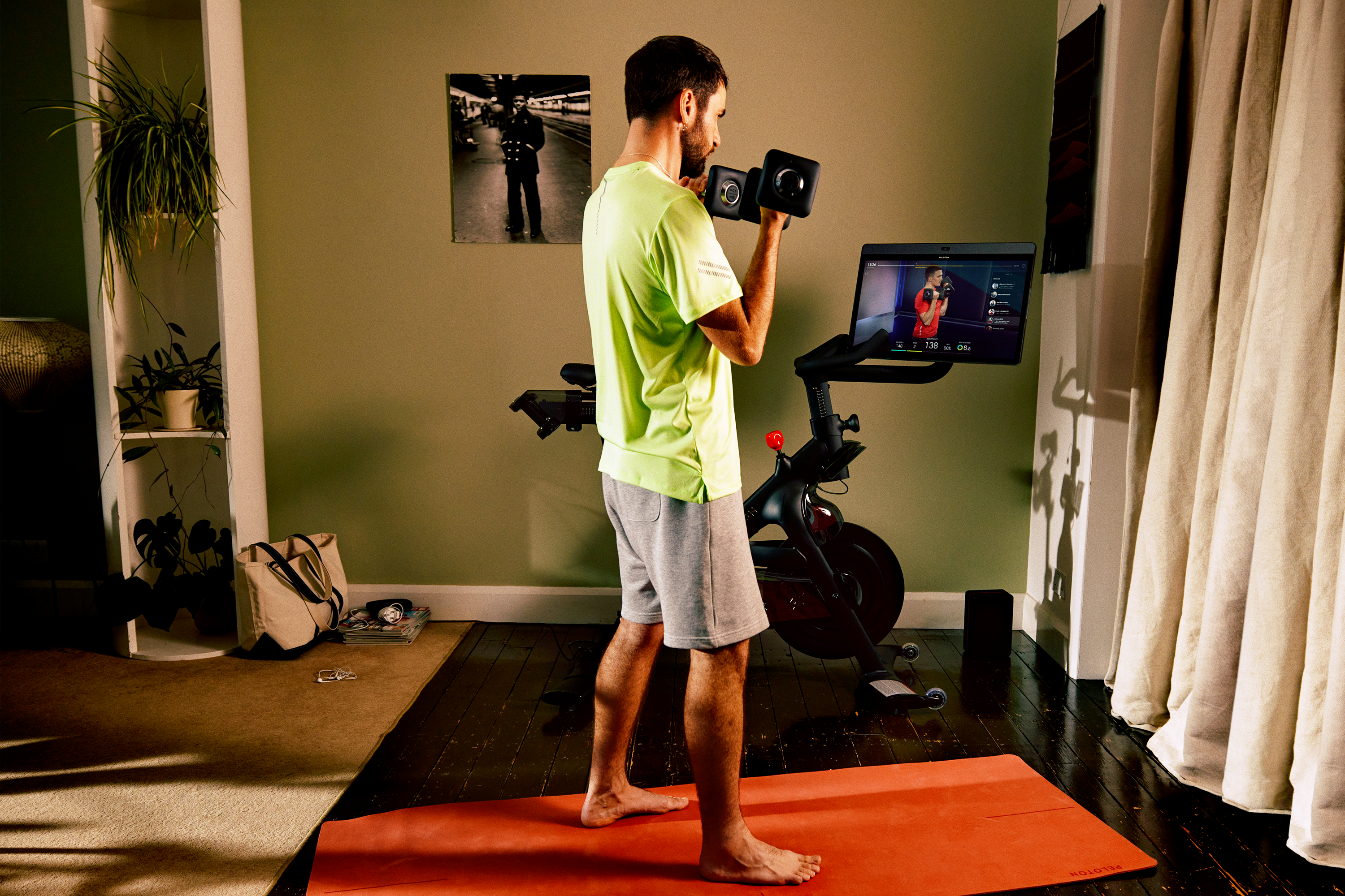 Man working out with Peloton bike in apartment.