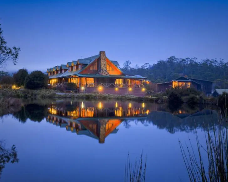 A view of Peppers Cradle Mountain Lodge by the lake at dusk, one of the best romantic getaways in Australia