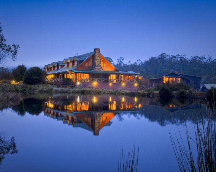 A view of Peppers Cradle Mountain Lodge by the lake at dusk, one of the best romantic getaways in Australia