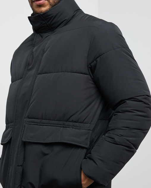 A person wearing a black jacket, one of the best men's puffer jackets. 