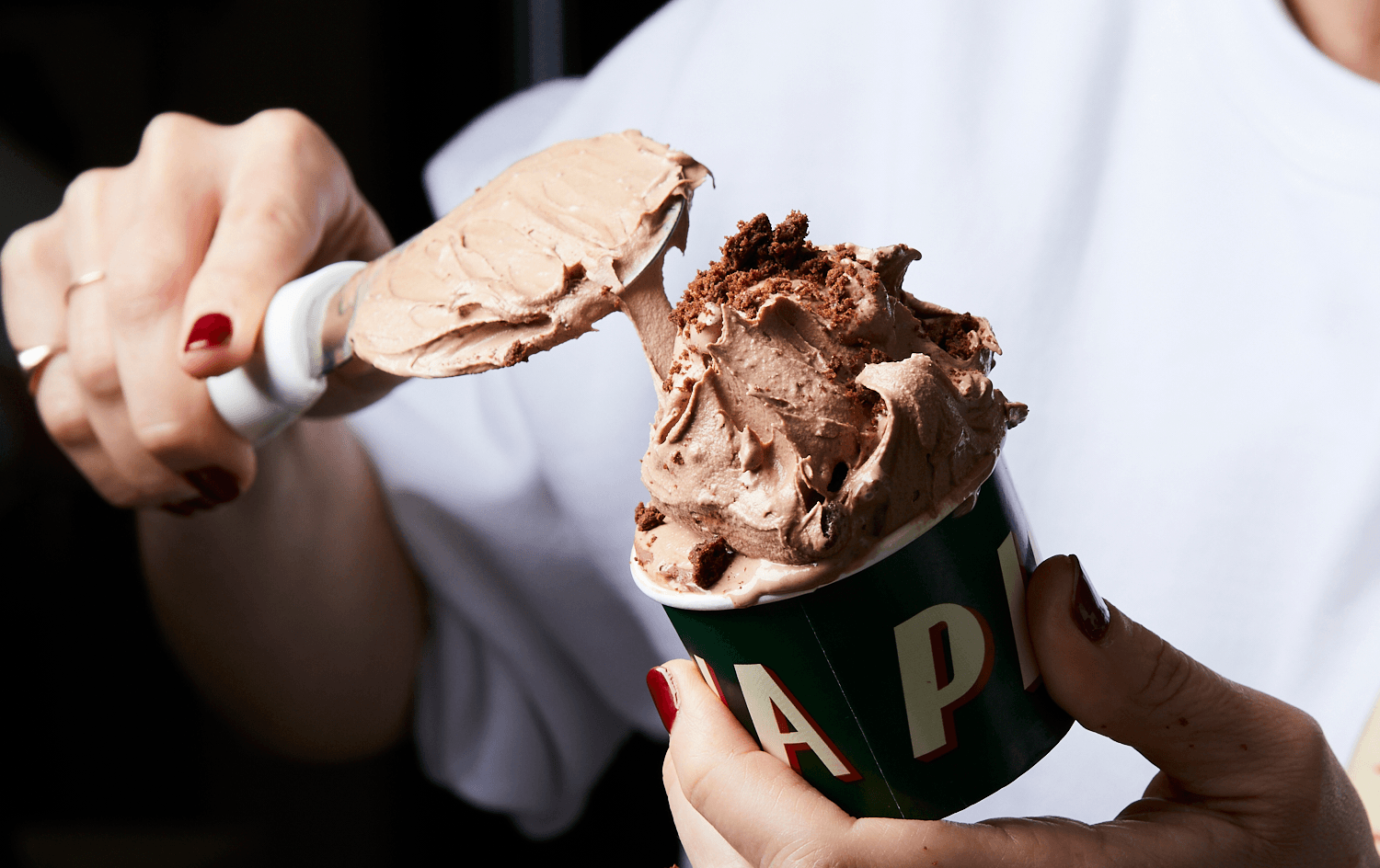 A person scooping a chocolate flavour of the best ice cream Melbourne has to offer.