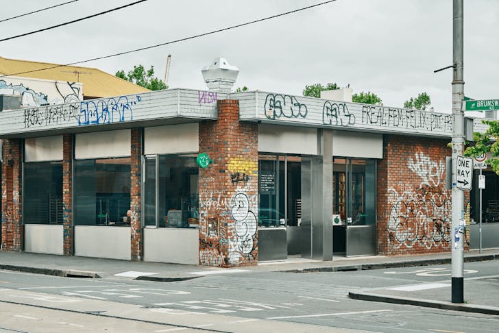 A corner building with brick walls covered in graffiti.
