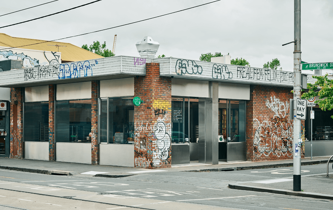 A corner building with brick walls covered in graffiti.