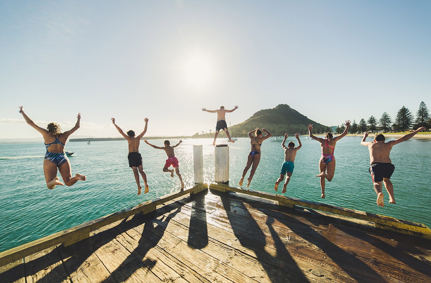 People leaping off the pier at Pilot Bay in Mount Maunganui.