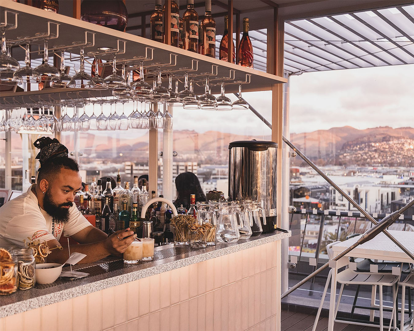 A bartender makes drinks at Pink Lady, a new rooftop bar in Christchurch.