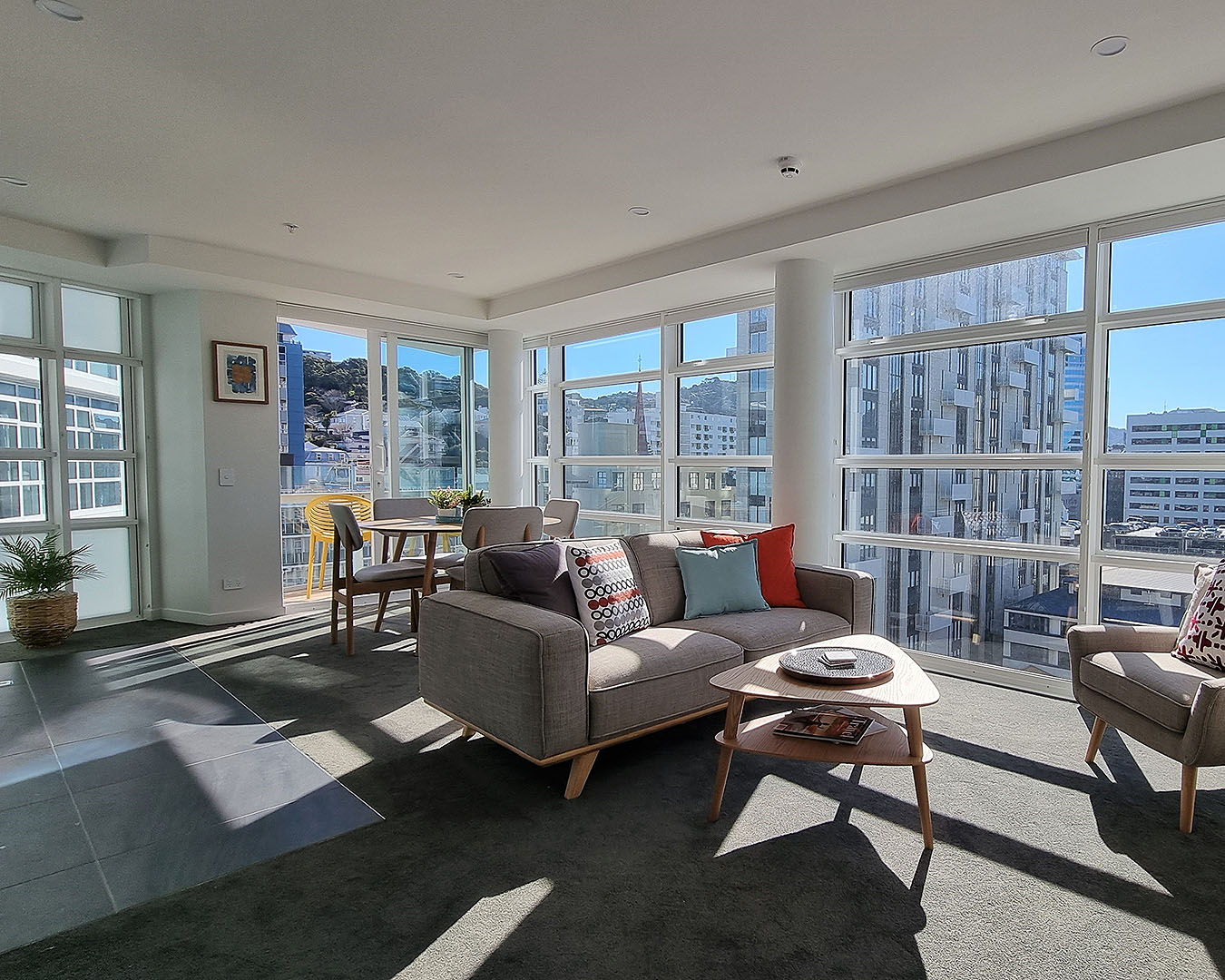 The large lounge of the Pinnacle apartment is lined by a floor-to-ceiling window with sweeping city views.