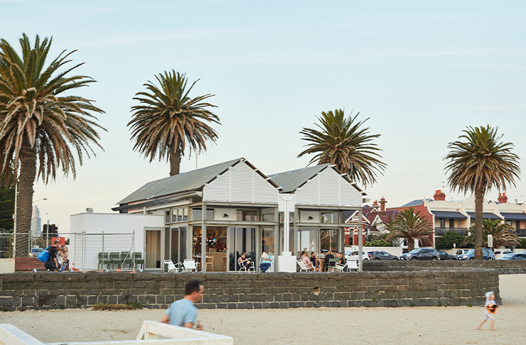 Three huge palm trees stand behind Pipis Kiosk, a small beachside restaurant offering lunch for mother's day in melbourne