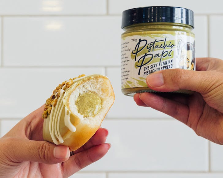 A pistachio-stuffed Krispy Kreme doughnut and a jar of Papi Pistachio. 